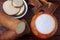 Tapioca flour in wooden bowl on rustic wooden table, next to cut and sliced cassava