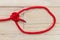 Tarbuck knot made with red rope on wooden background.