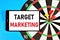 Target marketing. Text message in the smartphone screen on the background of a dartboard.