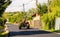 Targoviste, Romania - 2019. Farmer in red tractor rides on the new asphalt in the sunlight