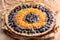 Tart with mandarins and cranberries on wooden background