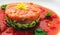 Tartar beefsteak with fresh cucumbers, olives and tomato sauce close-up