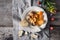 Tartiflette with tomatoes and bread on the white plate on the wooden table top view