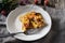 Tartiflette on the white plate on the wooden table horizontal