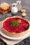 Tartlet with beetroot, parsley and goat cheese on a white plate