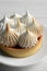 Tartlet with meringue on white wooden table, closeup. Tasty dessert