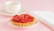 Tartlet with vanilla cream covered with slices of strawberry.