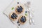 Tartlets with blueberries, bilberry, ricotta and honey syrup on vintage background from above. Delicious dessert. Flat lay styling