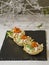Tartlets with cream cheese and smoked salmon on black slate. Festive New Year`s dish. Christmas snack. Close up, copy space,