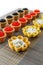 Tartlets filled with cheese and dill salad and caviar on bamboo placemat