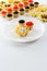 Tartlets filled with cheese and dill salad and caviar and plate with tartlets against white background