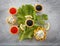 Tartlets filled with red and black caviar and cheese and dill salad on white plate against silver wooden background