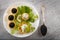 Tartlets filled with red and black caviar and cheese and dill salad on white plate against silver wooden background