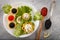 Tartlets filled with red and black caviar and cheese and dill salad on white plate against silver wooden background