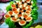 Tartlets on lettuce leaves with red caviar close-up. Buffet table with seafood, appetizer.