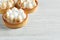 Tartlets with meringue on white wooden table, closeup. Tasty dessert