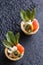 Tartlets with salmon and cheese cheese with micro-green on a dark background.
