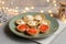 Tartlets with soft cheese, shrimp and red caviar. Holiday dish. On a green plate