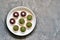 Tartlets stuffed with beetroot and mushroom mince sprinkled with dill in a white plate on a worn vintage background