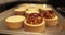 Tartlets on the table of a professional confectioner are decorated with apple-jelly