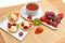 Tartlets with whipped cream and fruit, fresh fruit and a cup of