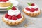Tarts with raspberries on marble table, closeup.