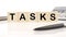 TASKS a word written on wooden cubes on a white background. Business concept