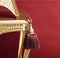 Tassel and golden chair on red background