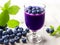 A Taste of Summer: Fresh And Juicy Blueberry Juice In Wine Glass Along with Berries And Leaves On Wooden Table. Ai Generated