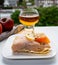 Tastes of Normandy, homemade baked crepe pancake with goat cheese and salmon and glass of apple cider drink with houses of Etretat