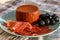 Tastes of Spain, jamon iberian, black olives and manchego cheese with red paprika