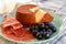 Tastes of Spain, jamon iberian, black olives and manchego cheese with red paprika