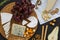 Tasting cheese with fruits, pretzels walnuts and bread sticks on dark background. Food for wine, romantic.