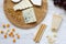 Tasting delicious cheese with grapes, walnuts, bread sticks and pretzels on wooden background, top view. Food for romantic.