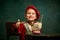 Tasting milk cocktail. Little charming kid in historical costume smiling and thumb up over dark green background