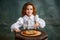 Tasting pizza. Portrait of little charming girl with curly hair in vintage blouse eating pizza over dark green