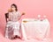 Tasting pizza. Young happy beautiful girl with retro style hairdo wearing medieval dress sitting at served table