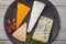 Tasting plate with four France cheeses, cream brie, marcaire, saint paulin and blue auvergne cheese, served with fresh ripe grapes