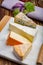 Tasting plate with four France cheeses, cream brie, marcaire, saint paulin and blue auvergne cheese, served with fresh ripe grapes