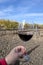 Tasting of red sangiovese wine with typical hilly vineyards and cypress tree on background near Montepulciano, Tuscany, Italy