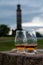 Tasting of single malt scotch whisky in glasses with view from Calton hill to new and old parts of Edinburgh city in rainy day,