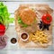 Tasty american hamburger with beef and french fries on wood background. Top view. Flat lay.