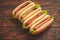 Tasty american hot dogs assorted in row. Placed on wooden table