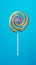 Tasty appetising party accessory sweet swirl candy lollypop on blue background top view. Generative AI