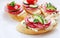 Tasty appetizers with cheese and salami over white