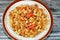 tasty appetizing classic ring pasta macaroni with tomato sauce and pieces, garlic, onion, spices, oil and black and green pepper,