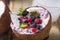 Tasty appetizing smoothie acai bowl made from blackberries and wild berries. Served in coconut bowl. Healthy life clean eating