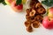 Tasty apple chips wrapped in paper on white wooden background