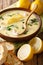 Tasty avgolemono lemon soup with chicken and rice served closeup in a bowl. vertical