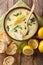 Tasty avgolemono lemon soup with chicken and rice served closeup in a bowl. Vertical top view